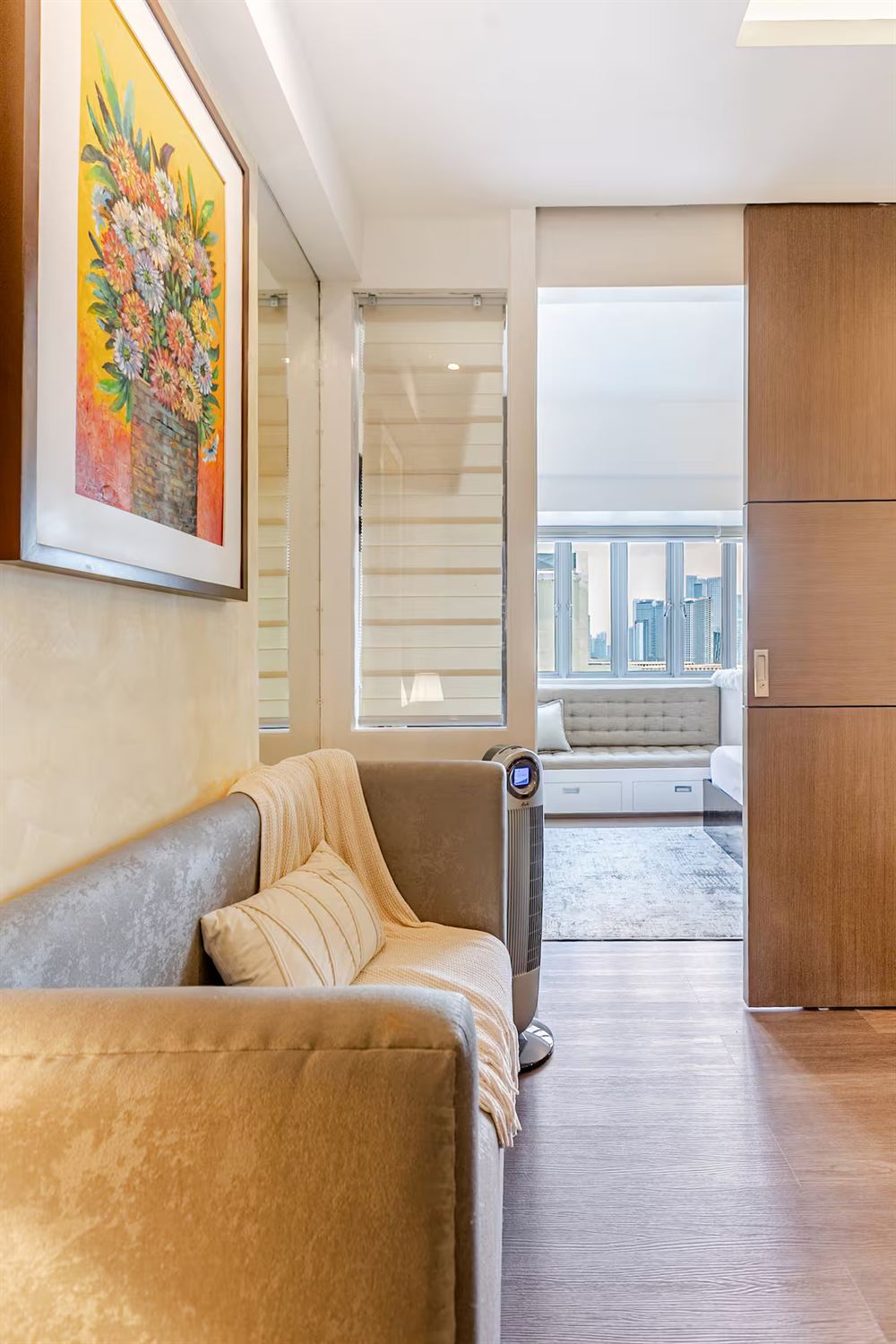 The living area looking through an open partition to the bedroom window seat and the skyline